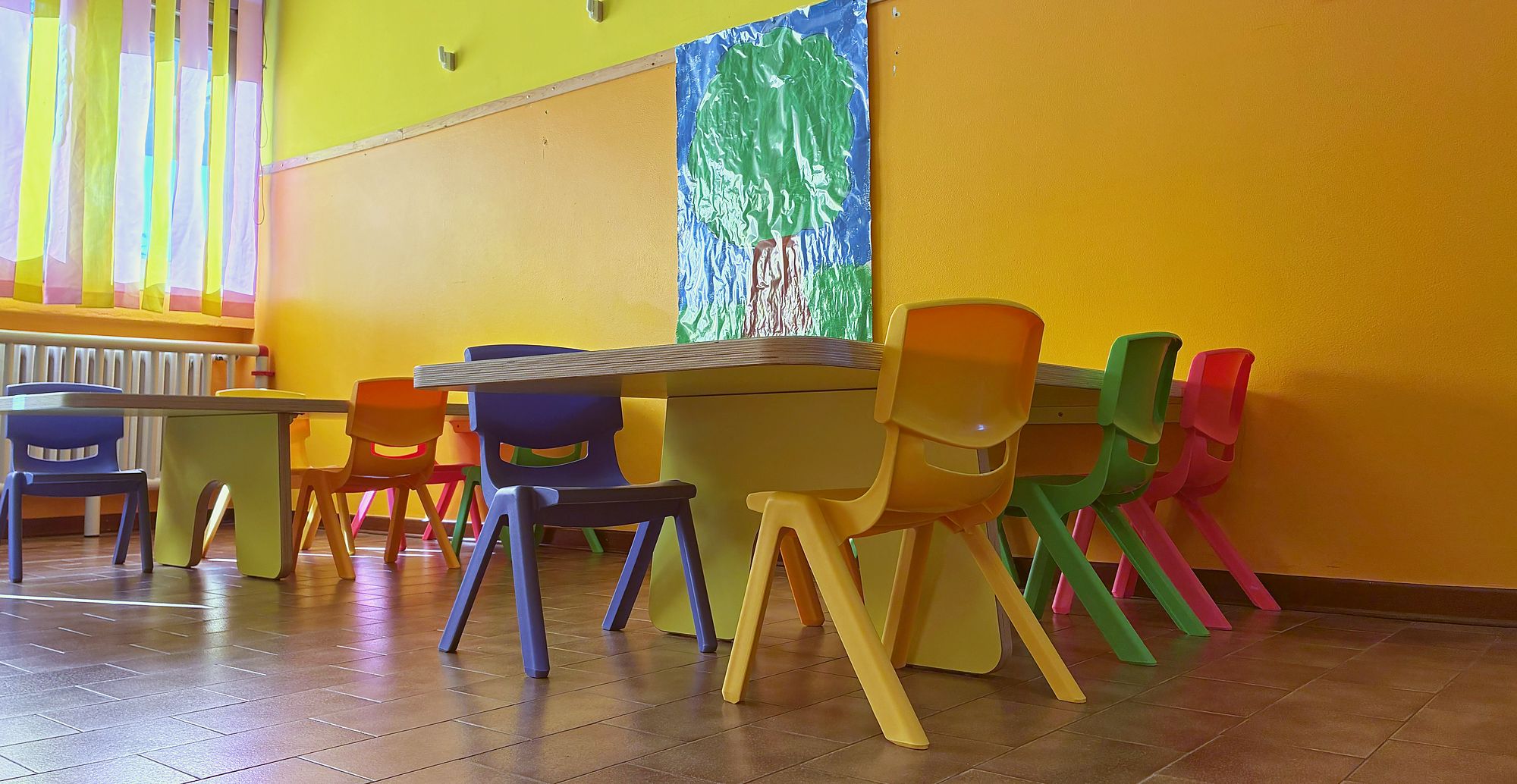 Tavoli e sedie colorate a misura di bambino nella sezione primavera
